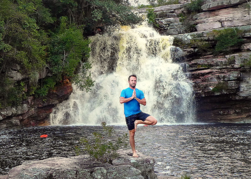 A day-tour companion performing yoga moves in front of a wet wonder.